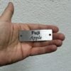Engraved stainless steel tree tag for a Fuji apple tree held in a hand